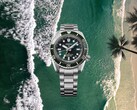 Orologio subacqueo Seiko Prospex HBC001 con quadrante e lunetta verdi visualizzati su uno sfondo aereo di spiaggia e oceano.