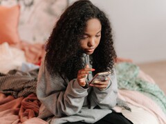 Adolescente che usa uno smartphone su un letto, immagine simbolica di ChatGPT for Teens e dei controlli parentali