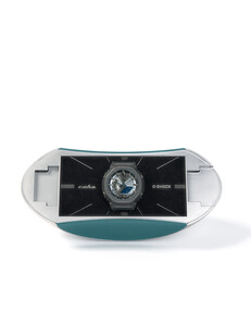 Custodia da collezione a forma di capsula, nei colori argento e verde acqua, dedicata alla collaborazione tra Casio G-Shock e C2H4.