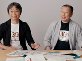 Uno screenshot di Shigru Miyamoto e Tezuka Takashi che indossano le magliette del 30° anniversario di Super Mario Bros