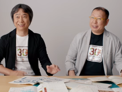 Uno screenshot di Shigru Miyamoto e Tezuka Takashi che indossano le magliette del 30° anniversario di Super Mario Bros
