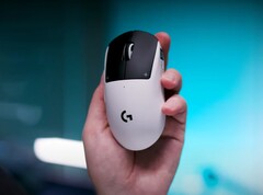 Il mouse da gioco Logitech G Pro X2 Superstrike in una mano su uno sfondo blu