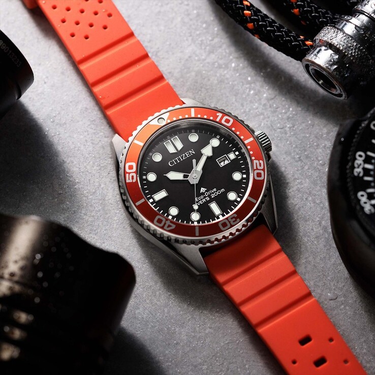 Orologio subacqueo Citizen Promaster Marine BN0268-01E con quadrante nero, lunetta arancione e cinturino arancione, fotografato su una superficie ruvida.