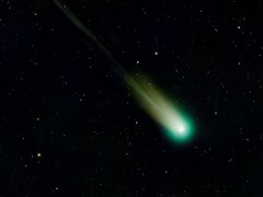 Un'immagine che mostra una cometa con una coda verde.