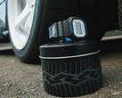Orologio Casio G-Shock DW5600TT25-1 x Toyo Tires esposto su una scatola di metallo a tema pneumatici, accanto a una ruota di automobile.