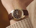 Timex Q 1978 Day and Date con quadrante fumé marrone e cassa color oro, mostrato al polso con un cinturino in pelle marrone.