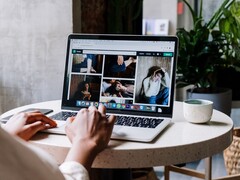 Persona che digita su un computer portatile in un bar, con una finestra del browser con la barra delle schede e la barra degli indirizzi sullo schermo