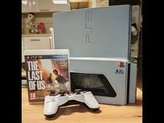 Una "PS3 Slim Pro" personalizzata costruita a mano con il logo del 30° Anniversario, accanto a un controller DualShock 3 e alla custodia di The Last of Us. (Fonte: Fun-Equivalent-7785 via Reddit / r/PS3)