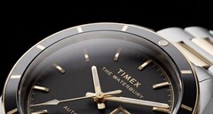 Primo piano del Timex Waterbury Heritage Automatic con quadrante nero, che mostra le lancette sfaccettate e luminescenti, gli indici delle ore, il datario con indicazione del giorno e la lunetta nera.
