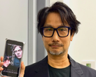 Hideo Kojima mostra un poster di Physint sul suo telefono
