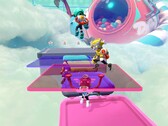 Schermata di Popucom con i personaggi su piattaforme tra le nuvole che risolvono i puzzle