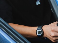Una persona che indossa l'orologio Casio G-Shock DW5600TT25-1 x Toyo Tires mentre è seduta all'interno di un'auto.