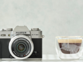 La fotocamera compatta APS-C Fujifilm X-T30 II accanto a una tazza di caffè