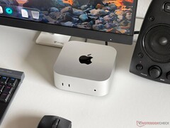 Mac mini con chip Apple M6 su una scrivania in una postazione da gioco con monitor, tastiera, mouse e altoparlanti.