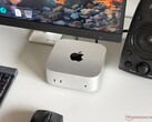 Mac mini con chip Apple M6 su una scrivania in una postazione da gioco con monitor, tastiera, mouse e altoparlanti.