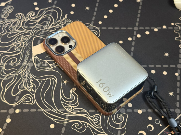 Il caricabatterie Ugreen Nexode Pro da 160 W a cinque porte posizionato sopra l’iPhone 16 Pro Max