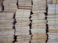 Alte pile di fascicoli cartacei raccolti in mazzi e legati con lo spago