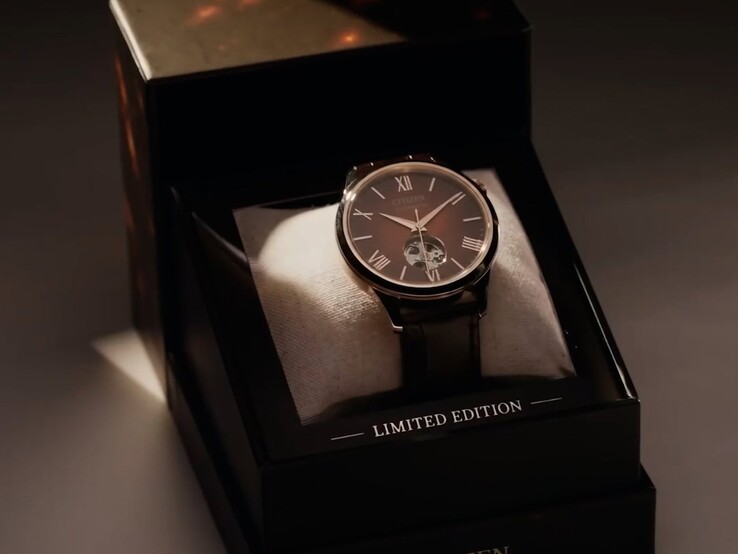 Un’inquadratura più ampia, illuminata in modo scenografico, dell’orologio Citizen appoggiato su un cuscino all’interno del suo cofanetto di presentazione scuro e a più livelli. Un caldo riflettore illumina il quadrante dell’orologio e la scritta «CITIZEN» è stampata sul bordo anteriore inferiore del cofanetto.