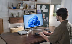 Minisforum ha rinnovato il suo mini-PC AI X1 Pro, nella foto accanto a un monitor e a una tastiera su una scrivania, con un nuovo hardware AMD (fonte: Minisforum)