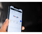 Una fotografia di una mano che tiene uno smartphone con la homepage di Google Search aperta sullo schermo. (Fonte immagine: Solen Feyissa su Flickr)