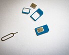 Schede SIM in tre formati e un perno di espulsione su una superficie bianca