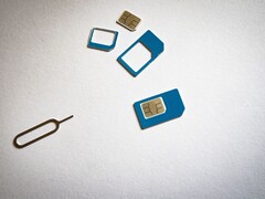 Schede SIM in tre formati e un perno di espulsione su una superficie bianca