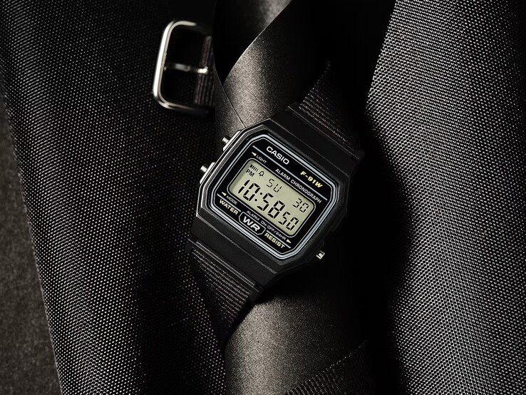 Orologio digitale Casio F-91WF-1A con cassa nera, cinturino in tessuto intrecciato nero e dettagli argentati, fotografato su uno sfondo scuro con texture.
