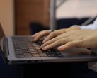 Mani che digitano sulla tastiera di un laptop scuro