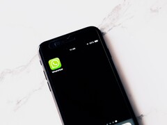 Smartphone su un tavolo bianco con l’app WhatsApp in primo piano