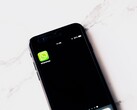 Smartphone su un tavolo bianco con l’app WhatsApp in primo piano