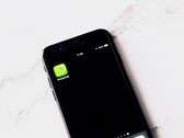 Smartphone su un tavolo bianco con l’app WhatsApp in primo piano