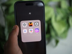 Una mano regge uno smartphone su cui è visibile una cartella denominata «AI» contenente app quali Gemini, ChatGPT e Claude