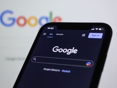 Smartphone che mostra la pagina di ricerca di Google davanti a uno schermo con il logo di Google
