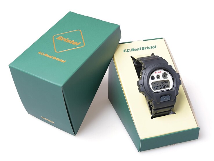 Il modello Casio G-Shock x F.C. Real Bristol DW-6900 è esposto all’interno di una confezione verde con marchio congiunto, affiancata dalla custodia esterna abbinata.