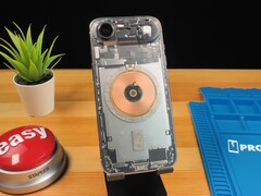 IPhone Air trasparente che mostra i componenti interni e la bobina di ricarica in rame su una scrivania di legno. (Fonte: Phone Repair Guru via YouTube)