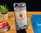 IPhone Air trasparente che mostra i componenti interni e la bobina di ricarica in rame su una scrivania di legno. (Fonte: Phone Repair Guru via YouTube)