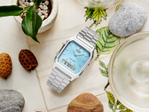 Il modello Casio AQ230A-2A1M è stilizzato in modo estetico su un tavolo.