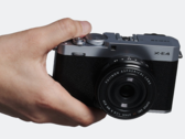 La fotocamera compatta a obiettivi intercambiabili Fujifilm X-E4 in mano