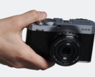 La fotocamera compatta a obiettivi intercambiabili Fujifilm X-E4 in mano