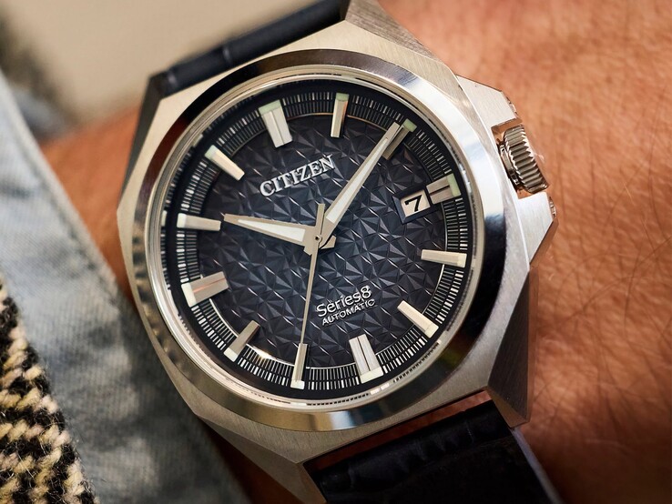Orologio automatico Citizen Serie 8 831 con quadrante geometrico nei toni dell’arancione bruciato e del marrone, cassa e lunetta color oro e bracciale integrato a maglie a H color oro, indossato al polso.