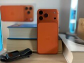 Apple l'iPhone 17 Air in finitura arancione mostra il design posteriore e il modulo della fotocamera posizionato su libri impilati