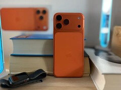 Apple l'iPhone 17 Air in finitura arancione mostra il design posteriore e il modulo della fotocamera posizionato su libri impilati