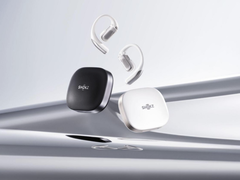 Lo Shokz OpenFit Pro (con custodia), raffigurato su uno sfondo argento stilizzato. (Fonte: Shokz)