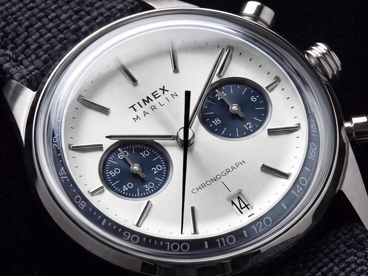 Primo piano del cronografo Timex Marlin Jet TW2Y89900 che mostra il quadrante bianco-argento, i quadranti secondari blu navy, gli indici applicati, le lancette a bastone, la scala tachimetrica e il datario.
