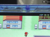 Primo piano della console portatile FPGBA SP blu trasparente con Pokémon in esecuzione e un contatore di 59.74 FPS visibile.