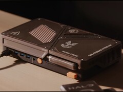 Una console di gioco compatta realizzata su misura, dotata di un mini PC, prese d’aria di raffreddamento a vista, porte USB e pulsanti di accensione arancioni, posizionata su una scrivania.