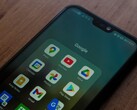 Smartphone su una scrivania di legno con una cartella dell’app Google aperta