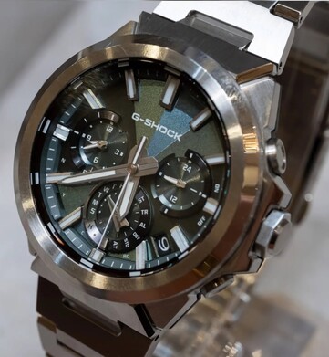 Primo piano del Casio G-Shock GST-W1000D-3A con quadrante verde, che mostra il quadrante dalla trama geometrica, i tre contatori, gli indici luminescenti e la lunetta in acciaio inossidabile lucido.
