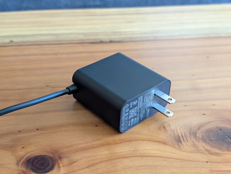 Alimentatore CA USB-C da 65 W fornito in dotazione con il Lenovo Yoga Slim 7 14. Si notino le spine CA non retrattili e il cavo USB-C integrato all’altra estremità
