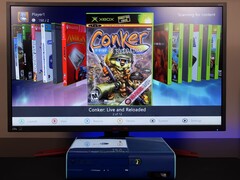 Una Xbox 360 blu moddata che esegue una dashboard homebrew personalizzata su un monitor, visualizzando il gioco "Conker: Live and Reloaded" insieme ad altri titoli Xbox ed emulatori. (Fonte immagine: Modern Vintage Gamer su YouTube)